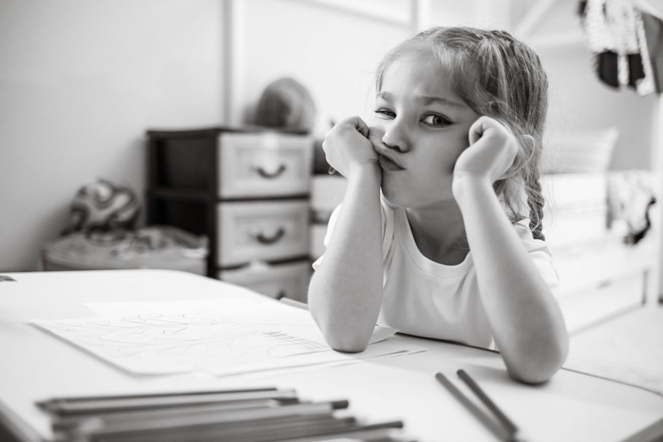 Cover image for the blog 'is it time we say goodbye to the CV'. Image shows a young child bored of writing, with paper all over her desk.