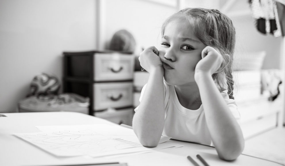 Cover image for the blog 'is it time we say goodbye to the CV'. Image shows a young child bored of writing, with paper all over her desk.