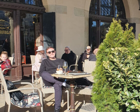 Photo of Billy sitting outside at a restaurant table.