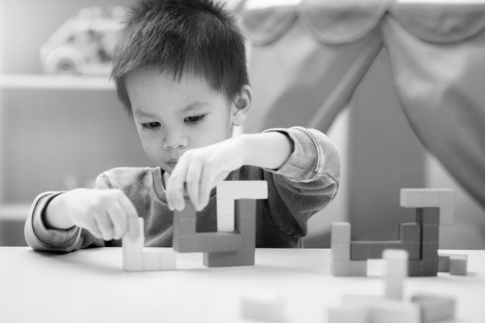 Small child building something with building blocks. Image is the cover for the top 5 Devops tools blog.