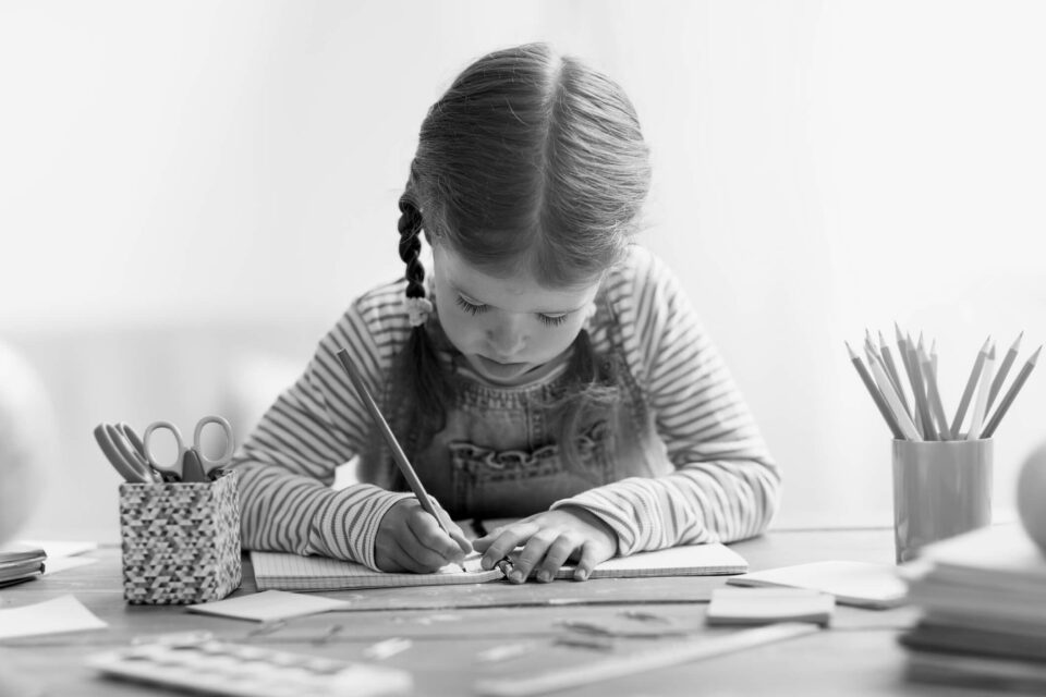 Black and white image of a girl drawing and painting. Cover image for the the Skills needed to be a UI_UX designer blog.