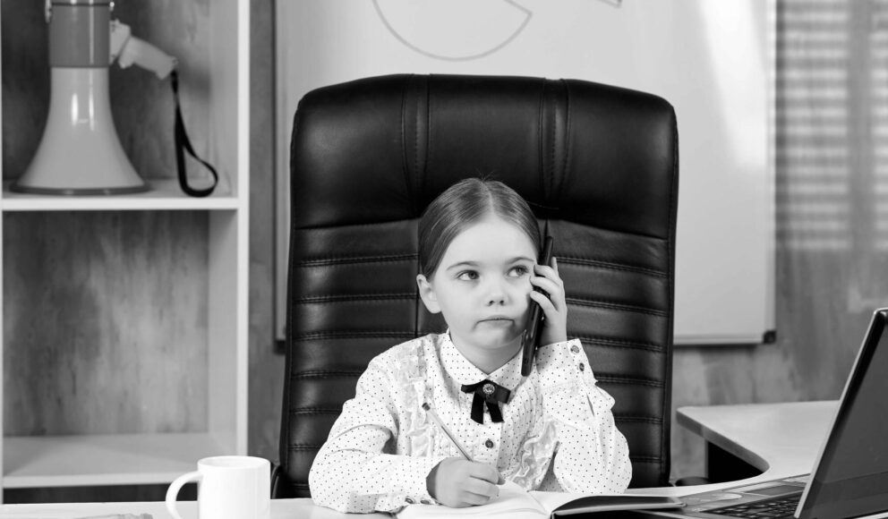 Black and white image of a girl sat at her desk on the phone. Image is a cover image for the recruitment tips for hiring managers blog.