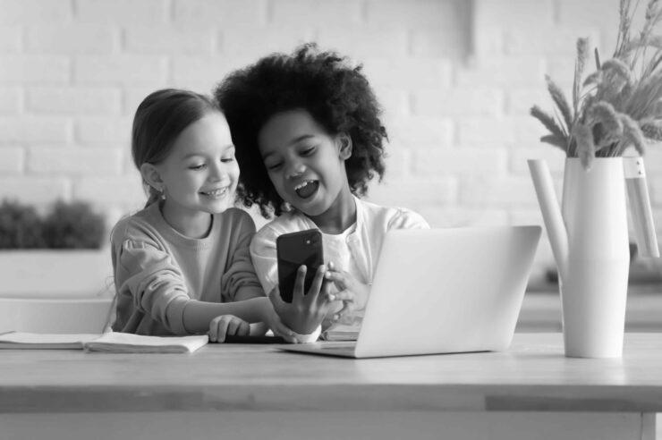 Black and white photo of two kids in front of a computer. Image is the cover for the top applicant tracking system blog