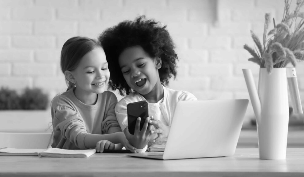 Black and white photo of two kids in front of a computer. Image is the cover for the top applicant tracking system blog