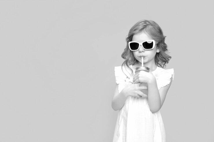 Black and white photo of a girl drinking from a cup, wearing sunglasses. Cover image for the how to hire a contractor guide.
